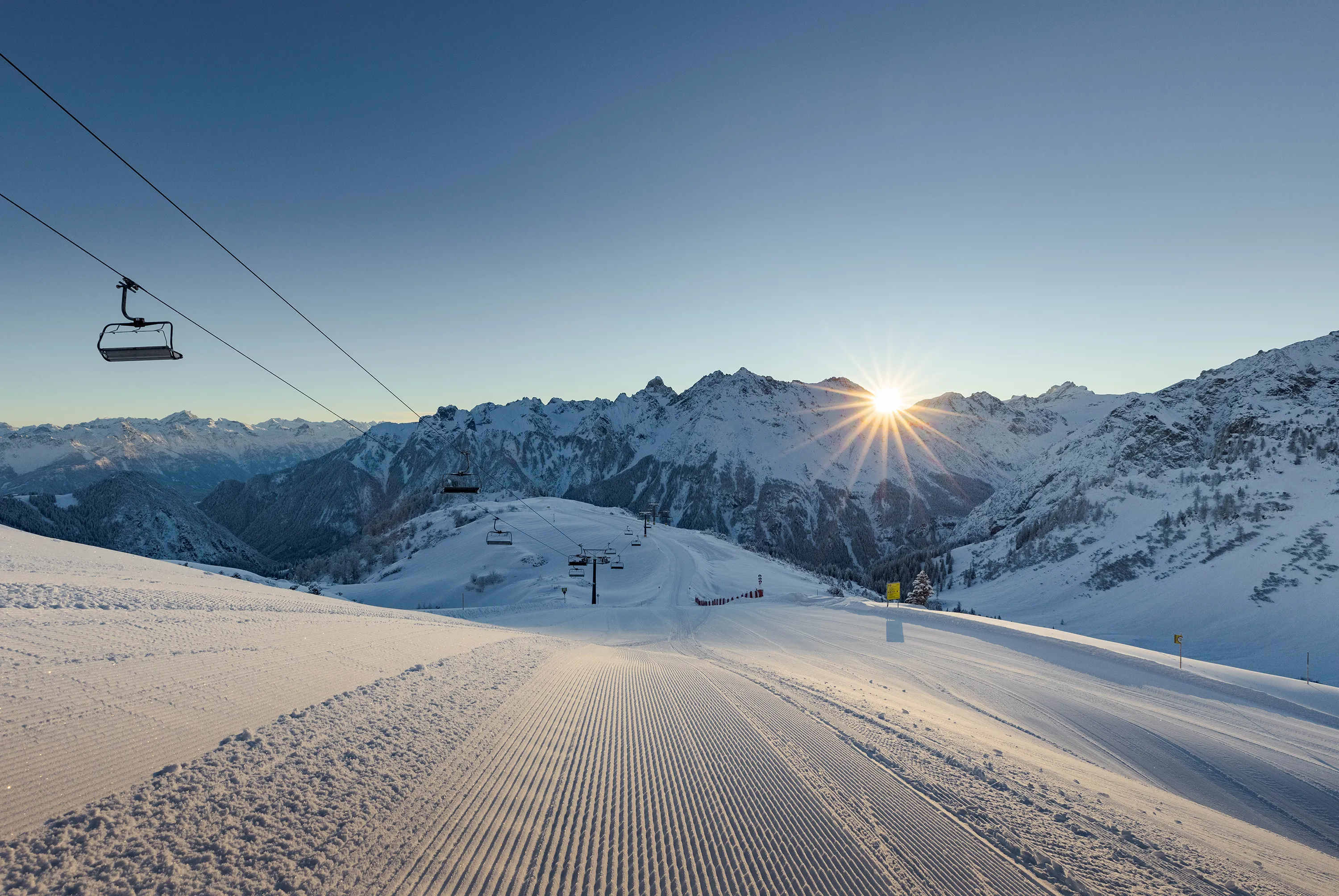 Brandnertal ski piste at sunrise with chairlift and Alpine peaks